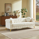 82-Inch Velvet Chesterfield sofa with two round pillows, featuring copper stud detailing and tufted button accents, with metal legs. Loop design allows for hanging cartoon ornaments.